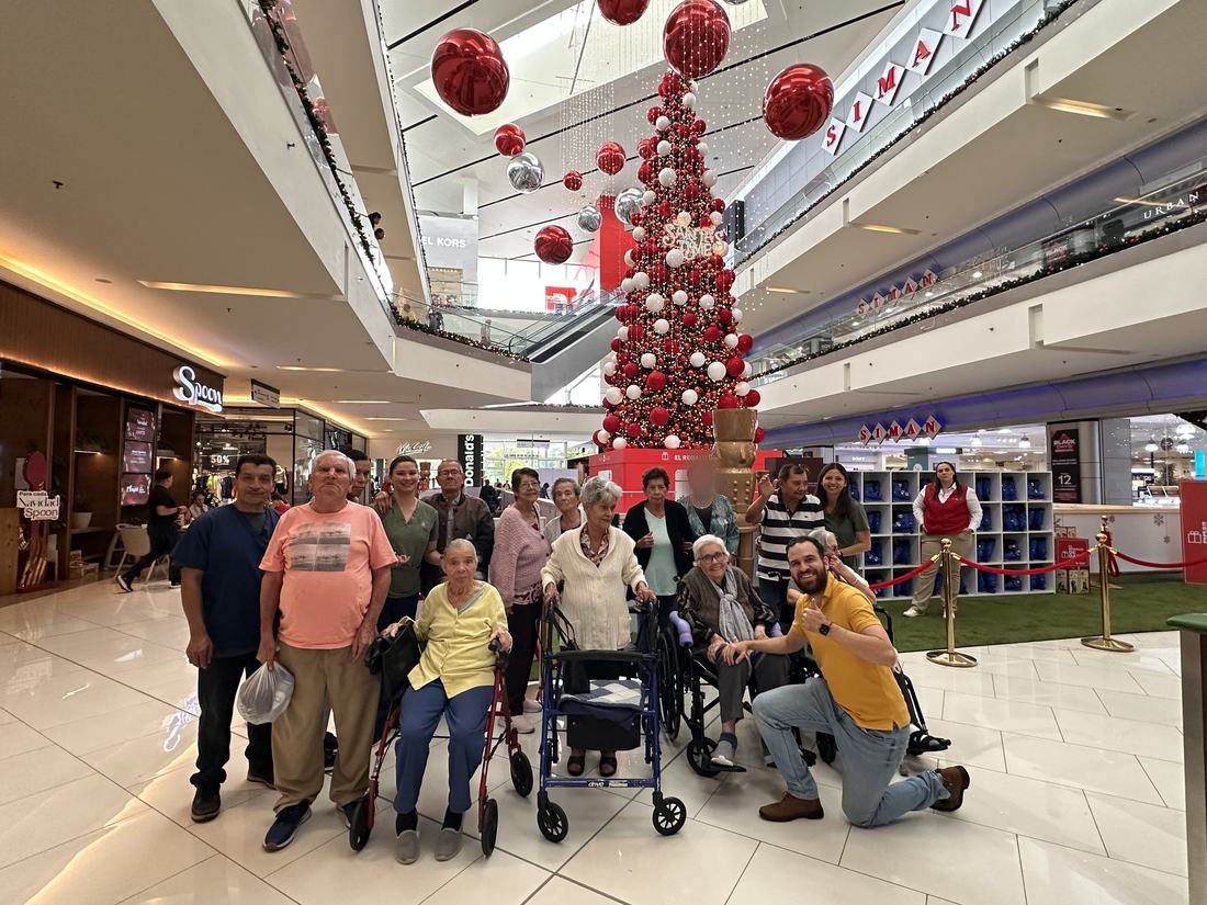 Residentes y personal en paseo navideño al centro comercial